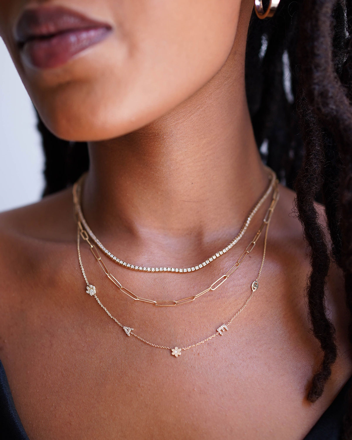 The 14K gold asymmetrical charm necklace styled on a model